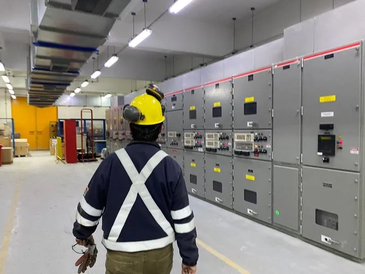 Técnico con casco amarillo frente a tableros eléctricos en Codelco